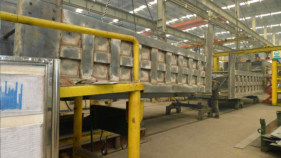 Poste de soudage robotisé à l’usine HOWO - plusieurs bras robotisés travaillent en même temps sur la ligne d’assemblage